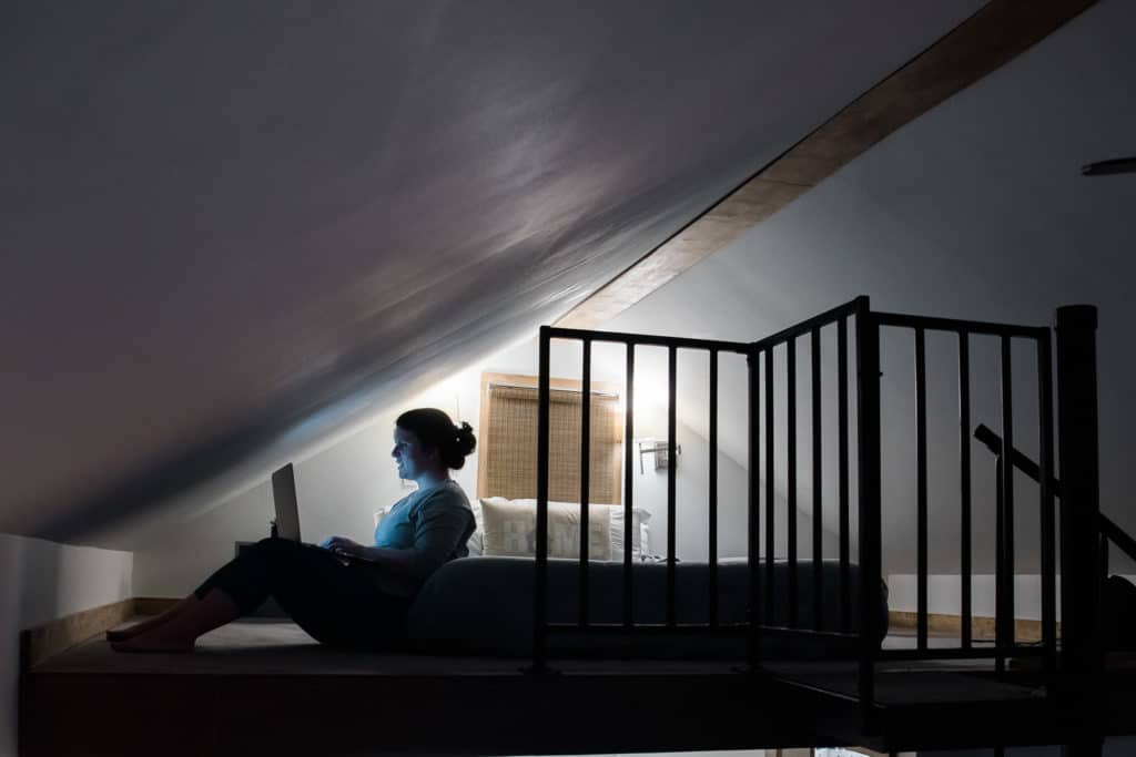 A personal brand coach studies in a loft lit by a laptop.