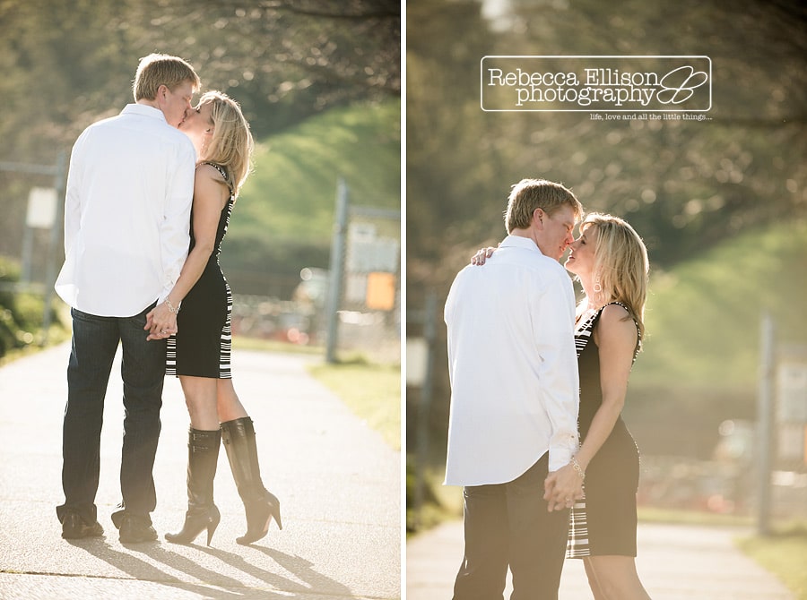 A couple kisses as they walk down a path during their Smith Cove Park Engagement portraits with Seattle engagement photographer Rebecca Ellison