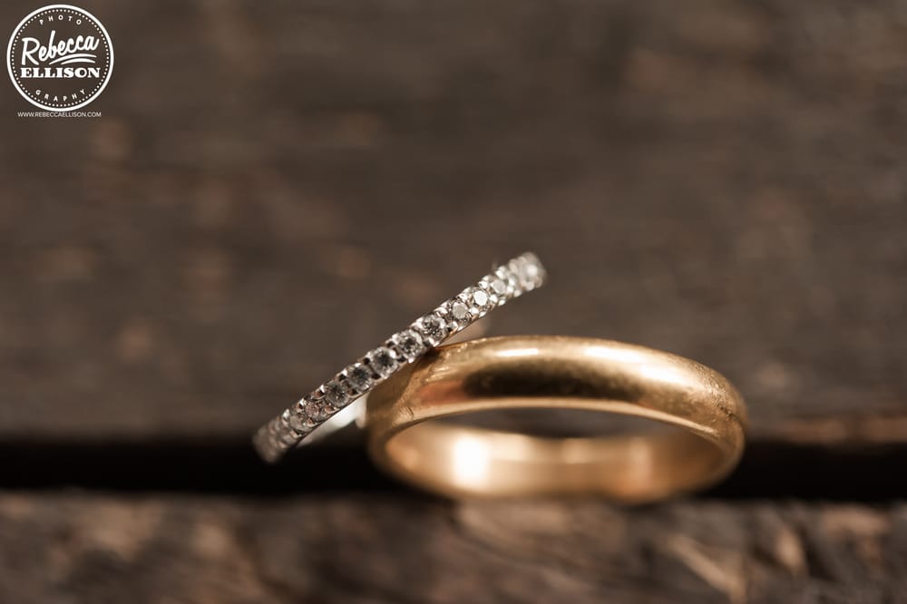 Wedding Rings sit on a rough wooden floor photographed by Seattle wedding photographer Rebecca Ellison