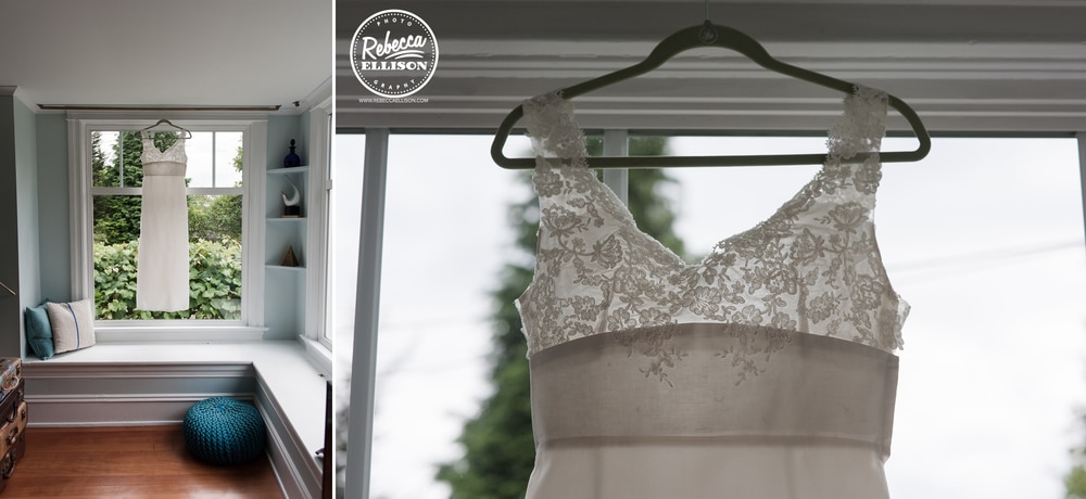White wedding dress with lace detail hangs in a window photography by Rebecca Ellison