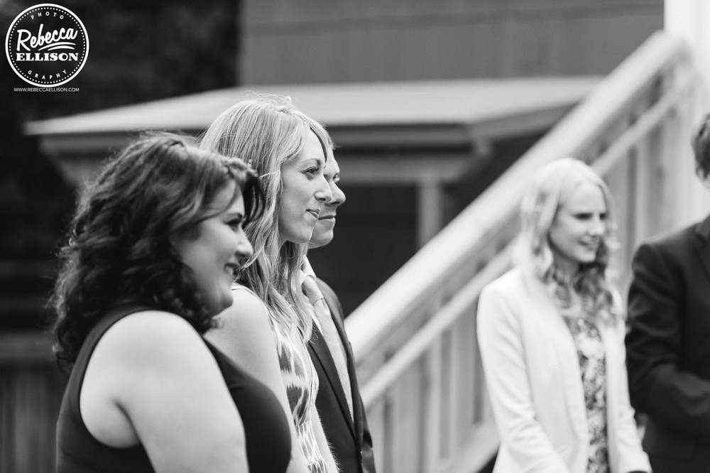 Bridesmaids watch during a weddinf ceremony at an intimate backyard wedding photographed by Seattle wedding photographer Rebecca Ellison