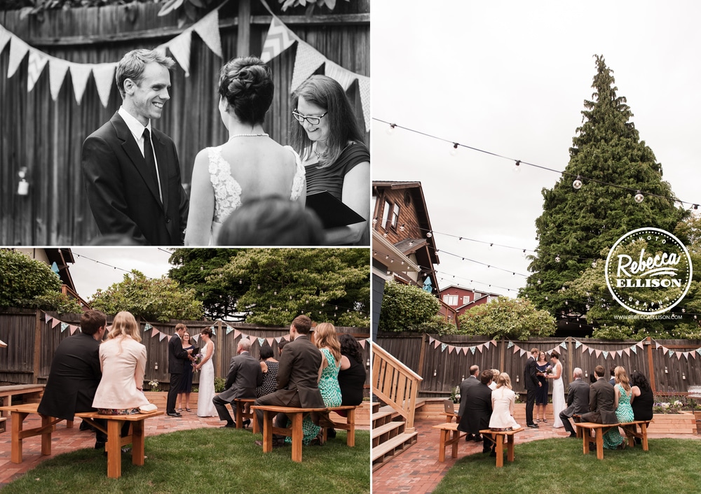 Wedding guests sit on wooden picnic benches at an intimate backyard wedding featuring light strings and penant banners photographed by Seattle wedding photographer Rebecca Ellison