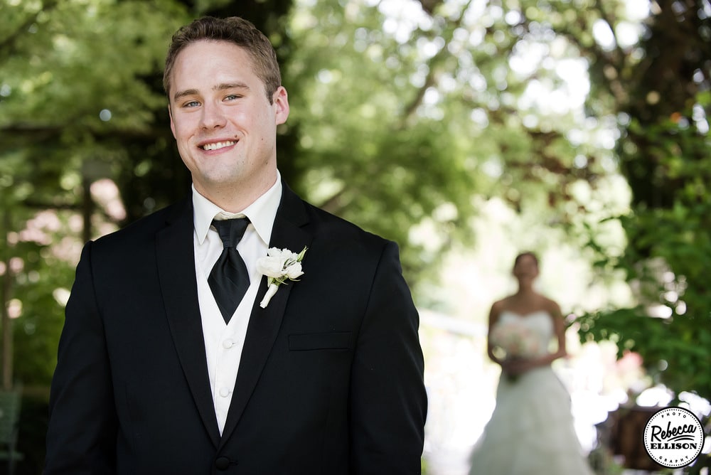 Groom waits for his first look at his bride during an outdoor wedding portrait session photography by Rebecca Ellison