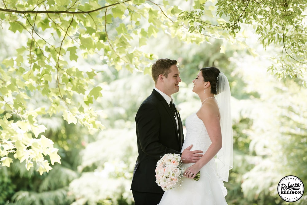 Bride and groom under a canopy of leaves during outdoor wedding portraits photographed by Seattle wedding photographer Rebecca Ellison