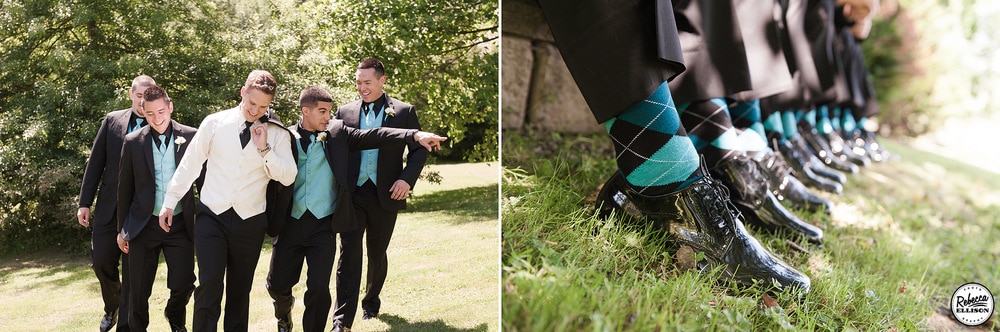 Groomsmen during outdoor wedding portraits walk through a garden wearing black suits with blue vests and ties and black and blue argyle socks