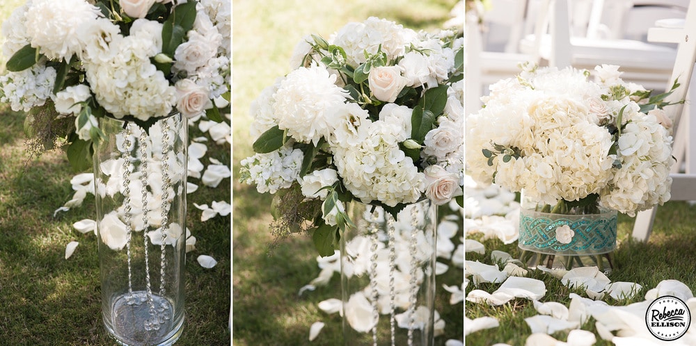 vases filled with crytals and white flowers line the wedding aisle at an outdoor garden wedding photography by Rebecca Ellison