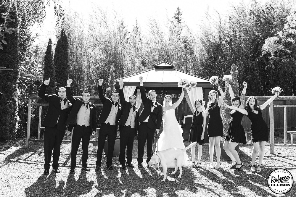 Wedding party celebrates after the ceremony in a black and white outdoor wedding portrait photography by Rebecca Ellison
