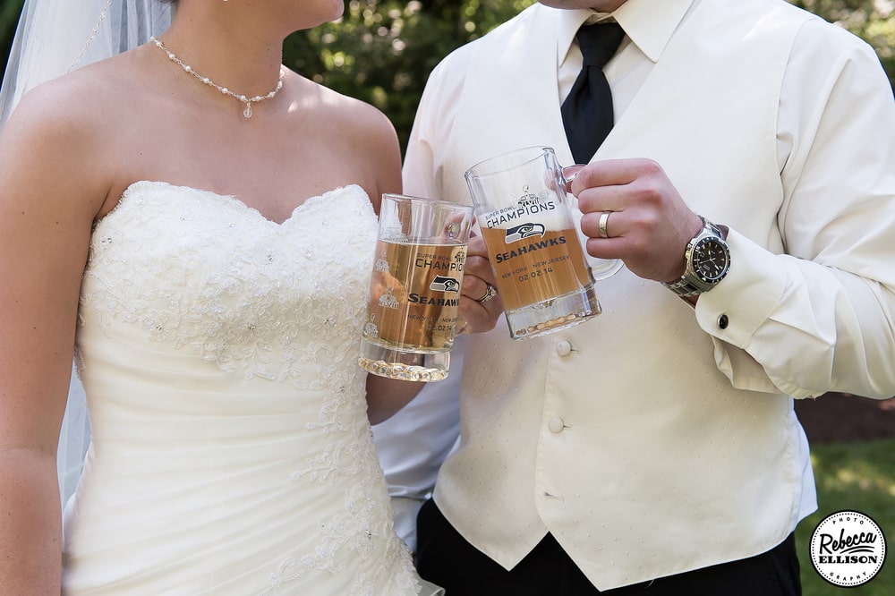 Bride and groom drink beer out of Seattle Seahawks beer steins at their outdoor garden wedding photographed by Seattle wedding photographer Rebecca Ellison