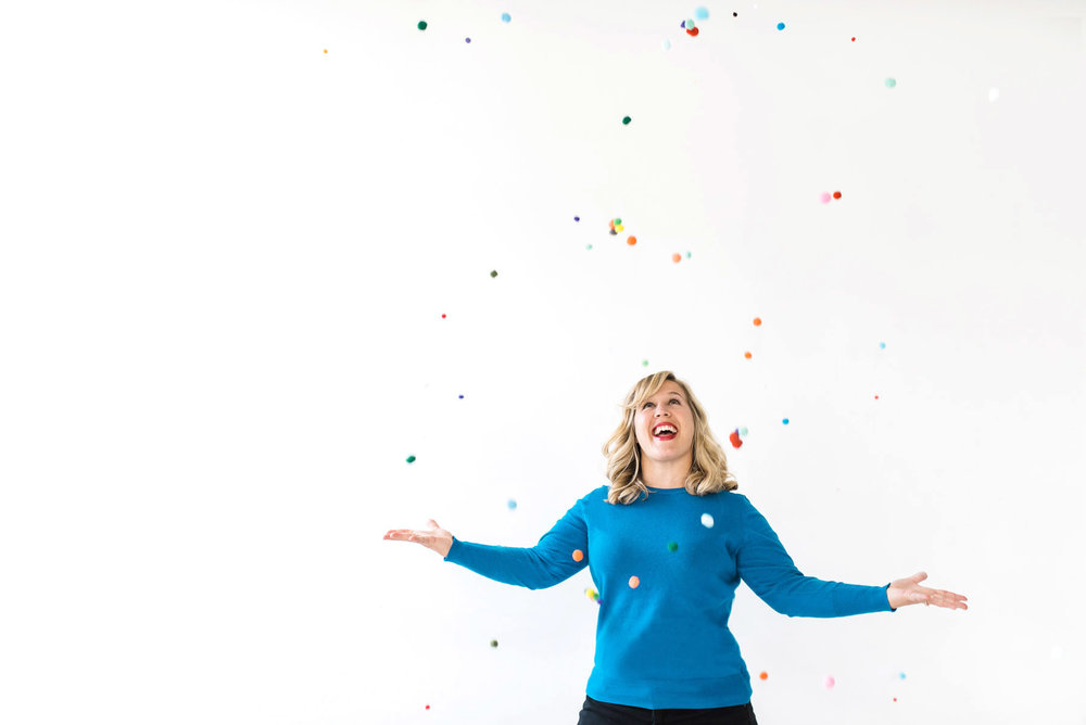 branding photo of woman throwing confetti in front of a white wall
