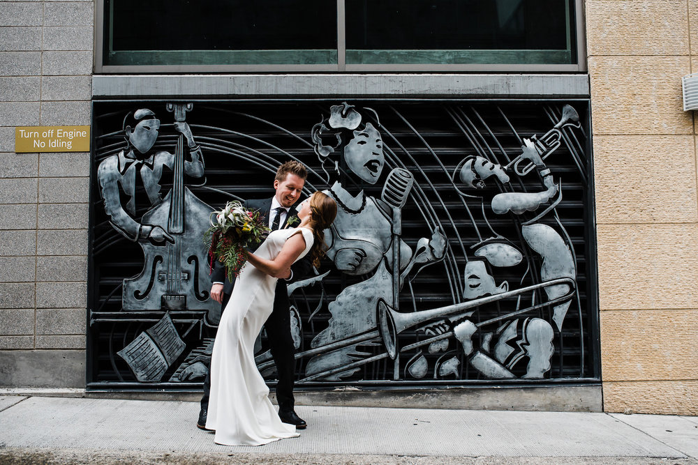 Couple poses by jazz art wall by Palace Ballroom wedding venue in Seattle